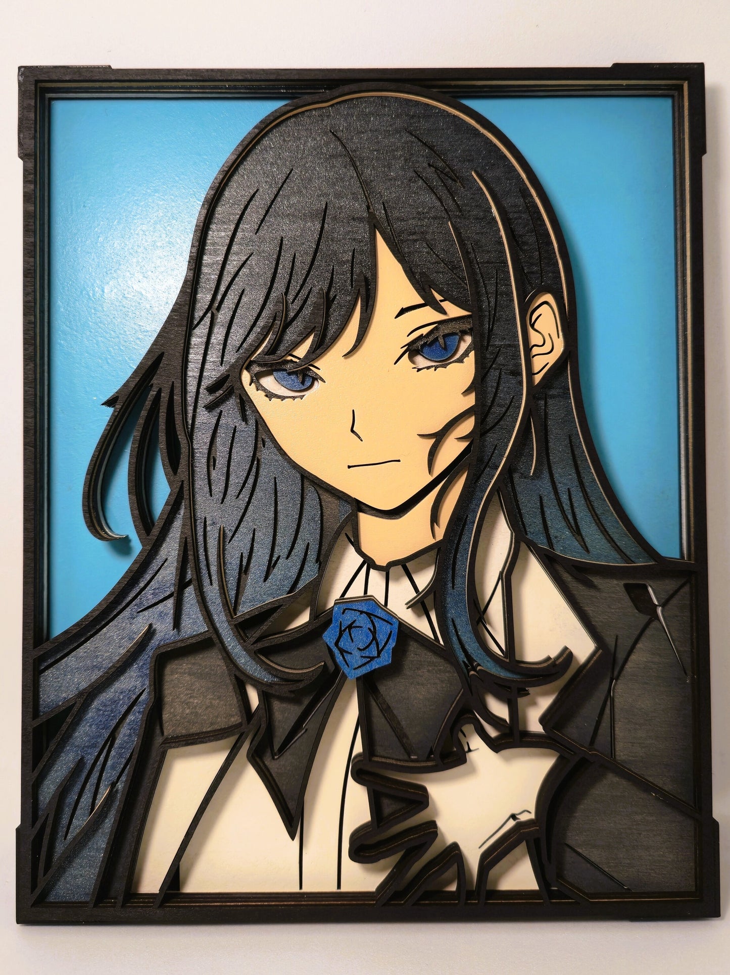 Tableau en bois multicouche de la chanteuse Ado style manga, portrait 3D découpé au laser avec détails peints en bleu et rose bleue sur le col - Création SF Gravure.